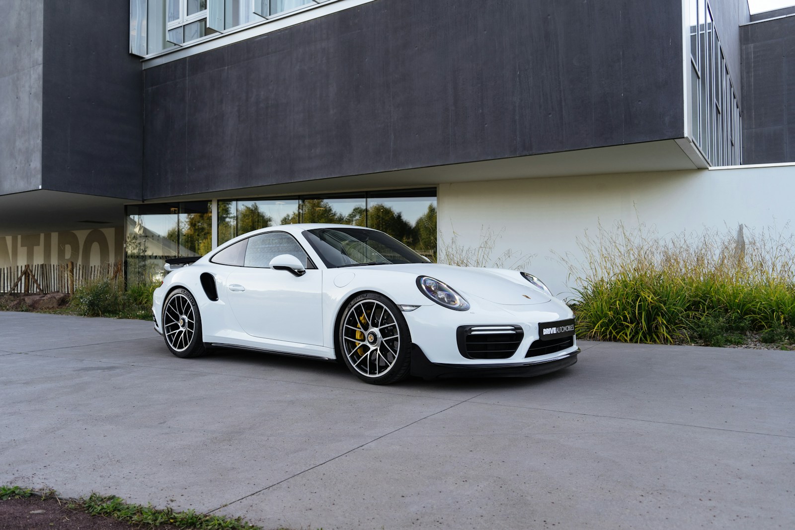 Witte Porsche voor een gebouw